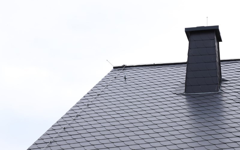 light blue slates on a roof and chimney on a left light blue sky