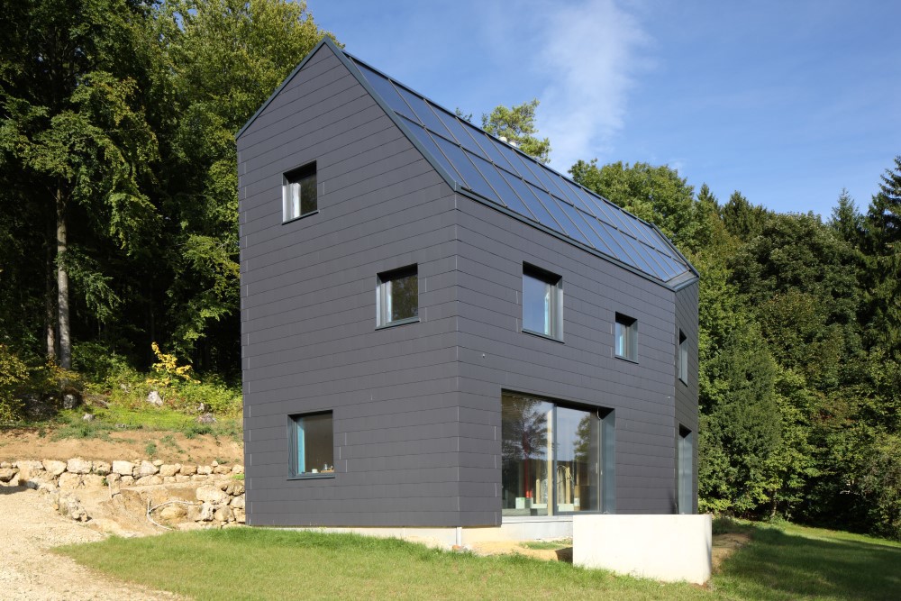 Gebäudehülle aus blauschwarzen Faserzementplatten 