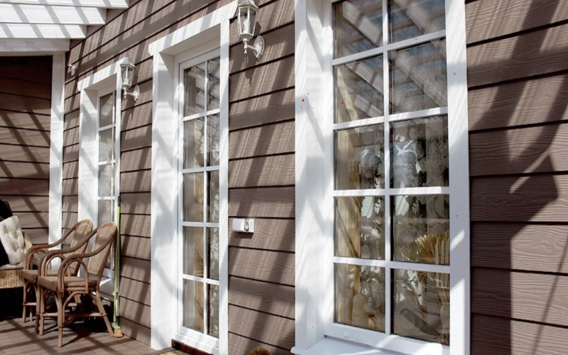 Cedral brown weatherboards on a house exterior white frame windows