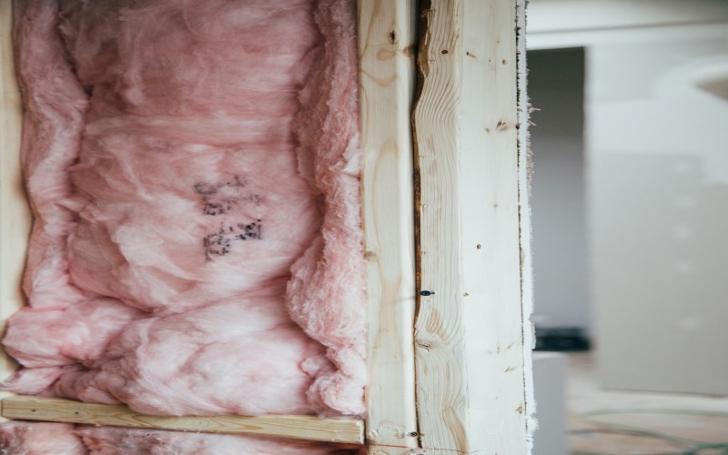 on the left pink insulation on the right white wall and door