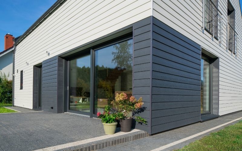 blue and white sidings on an exterior wall grey ground and big windows