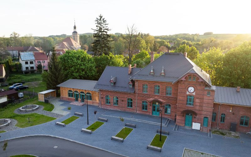Widok na fasadę dworca w Leśnej z odtworzoną oryginalną kolorystyką elewacji