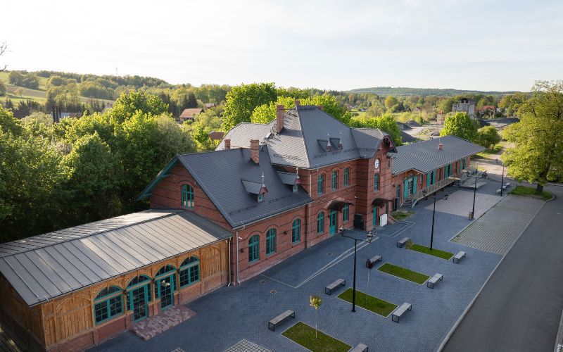 Widok boczny budynku z oryginalnymi drzwiami magazynowymi i nowym pokryciem dachowym