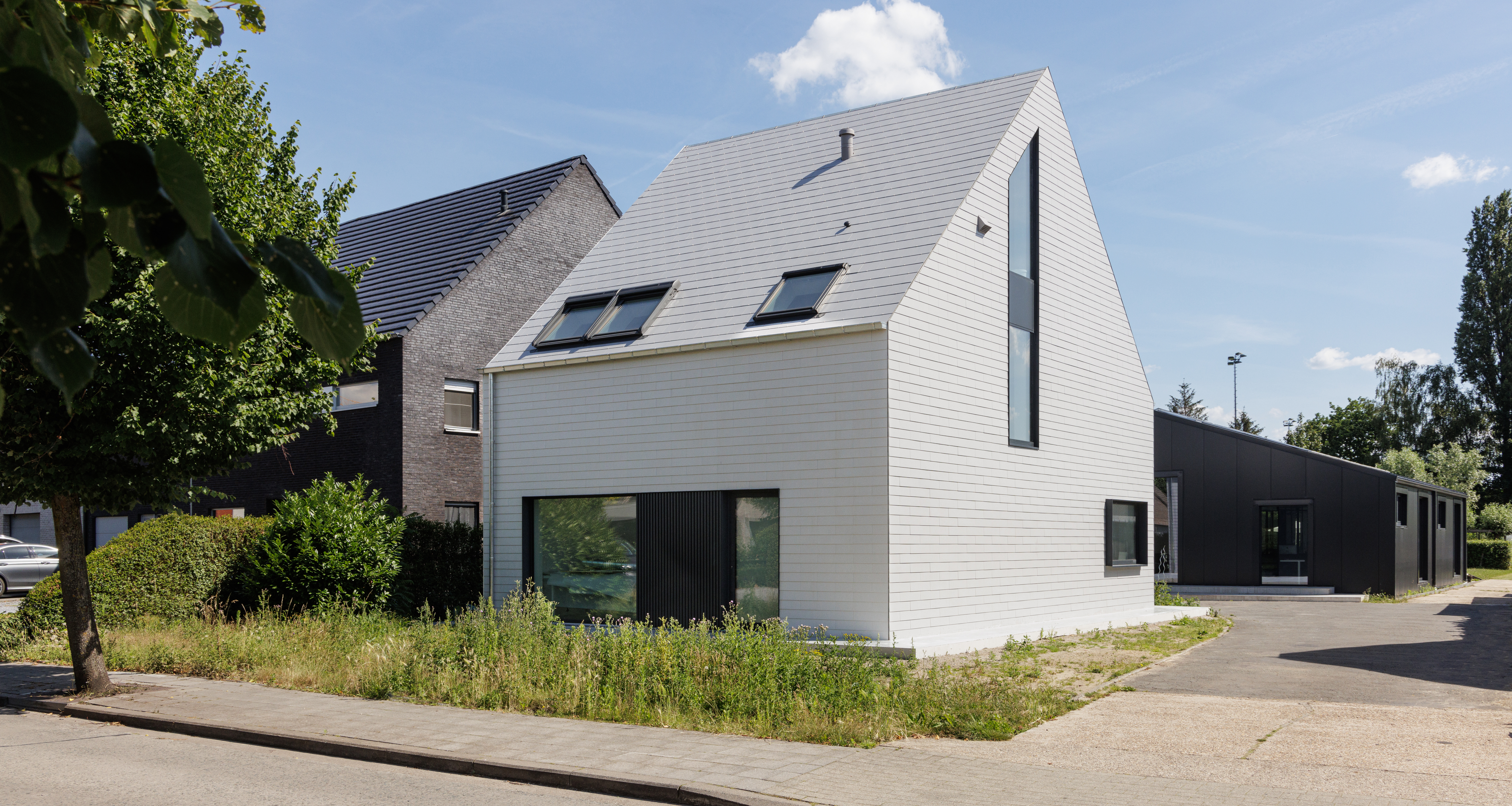 Moderne woning met dak en gevel in witte Cedral vezelcement leien te Beveren