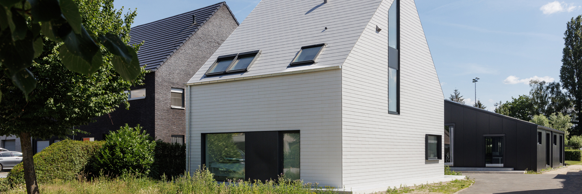 Moderne woning met dak en gevel in witte Cedral vezelcement leien te Beveren