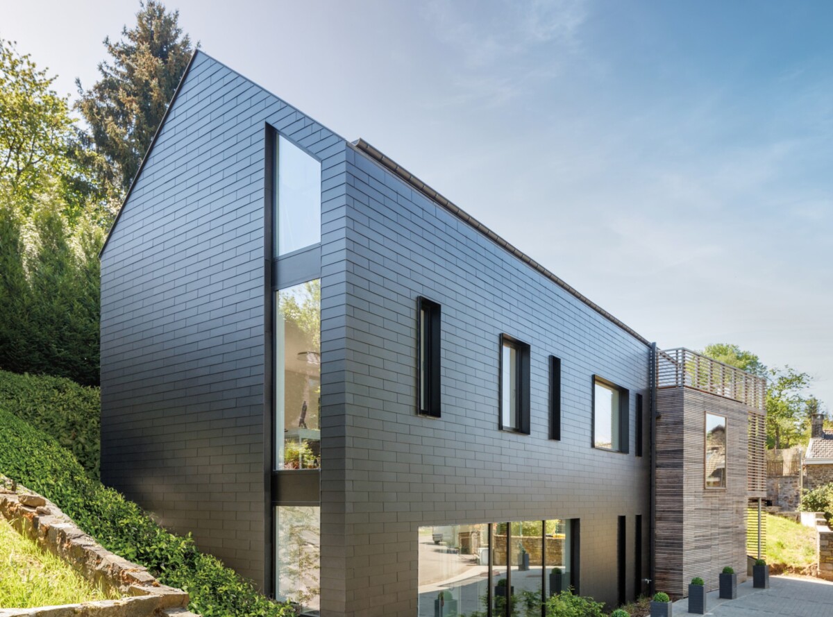 Sleek black fibre cement slate facade materials by Cedral featuring large vertical windows