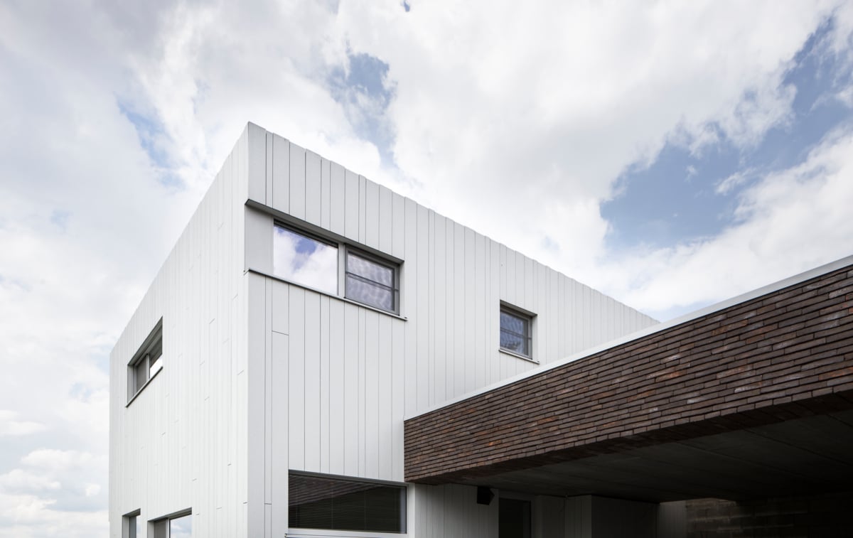 Kubisches Wohnhaus mit vertikal montierten Cedral Paneelen in natürlicher Holzstruktur.