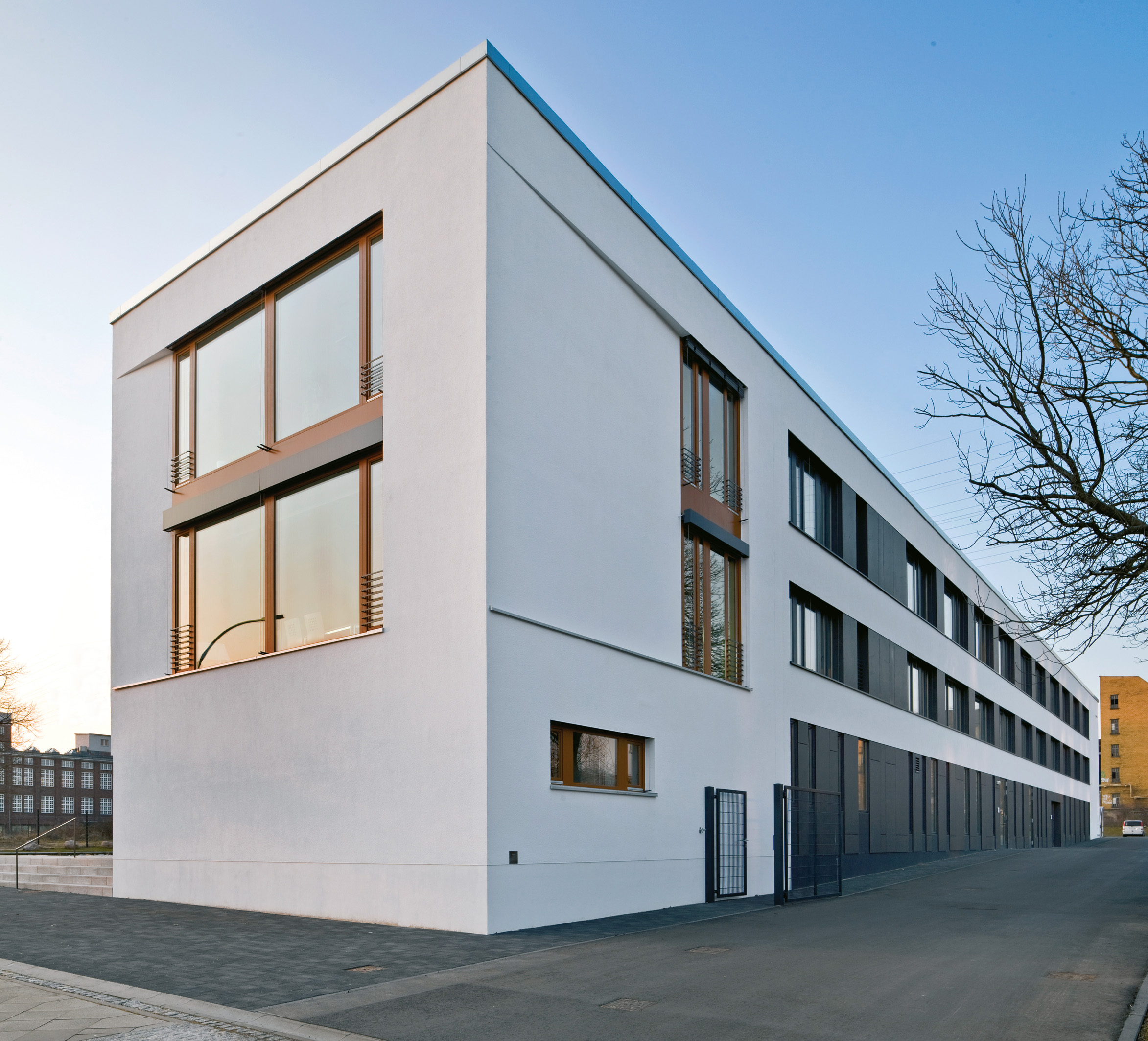 Dreigeschossige Werkstatt für behinderte Menschen in Berlin‑Zehlendorf mit Cedral Bluclad Fassadenplatten und großen Fensterflächen.