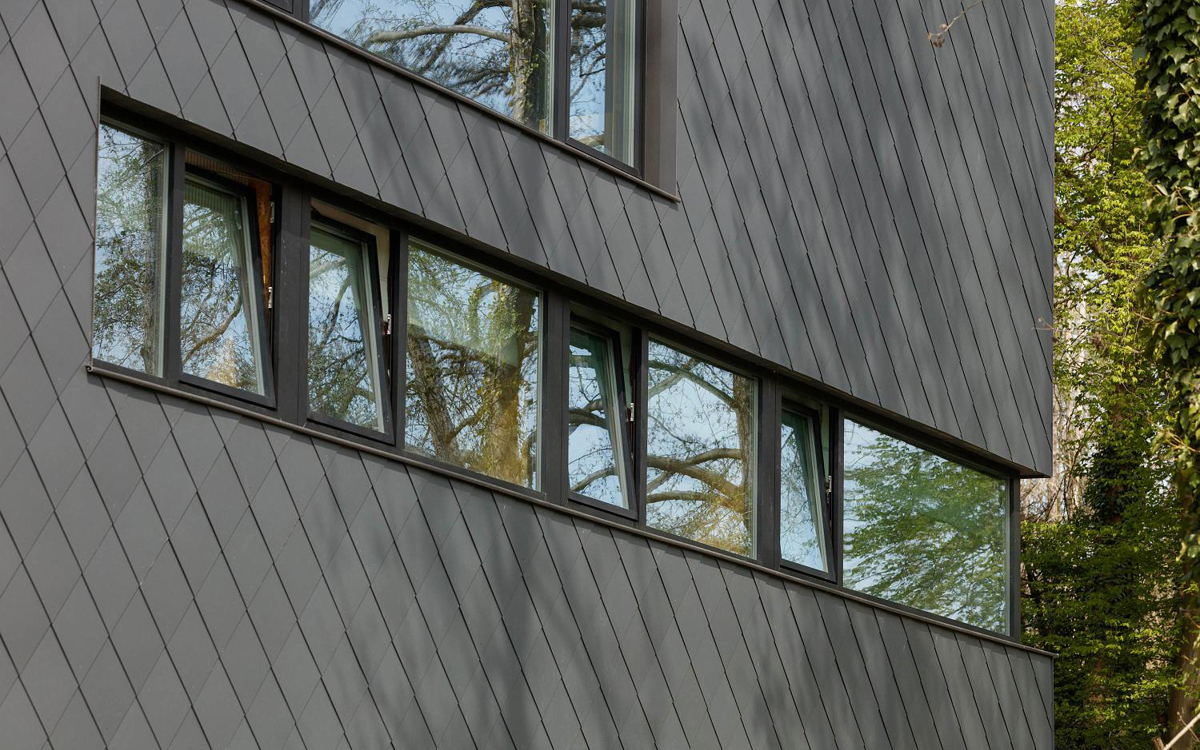 Une maison unifamiliale élégante et épurée par un revêtement en ardoise gris foncé